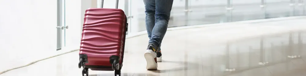 A man carrying a suitcase at the airport terminal